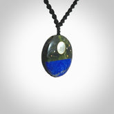 This photo shows a medium sized disc pendant hand carved from Lapis Lazuli and New Zealand Jade with Mother of Pearl inlay and copper, gold, and silver. This is a stand out one off necklace for those who appreciate art to wear. It is provided with a cord in black that is a fixed length with Paua Shell Toggle. We ship this piece worldwide and shipping is included in the price.